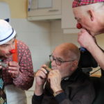 VisiteClowns spelen mondharmonica met een bewoner